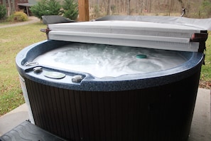 Hot tub located outside with mountain and water views