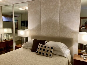 Comfortable queen bed in bedroom.