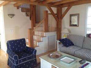 View of living room showing oak post and beam features and stairs to 2nd floor