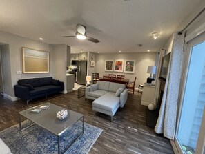 Casual living room with lots of light and easy access to the back deck.  