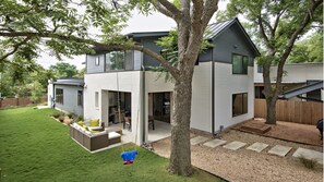 Backyard area with outdoor seating for all, a table and a Weber grill