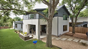 Backyard area with outdoor seating for all, a table and a Weber grill