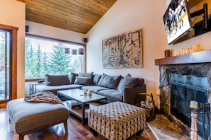 comfy living room with plenty of seating and wood burning fireplace