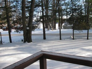 View of the lake through the trees from the front porch in the winter.