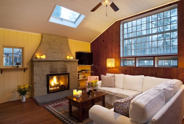 Cozy up to a fire in the gas-fueled fireplace under skylights + oversize windows