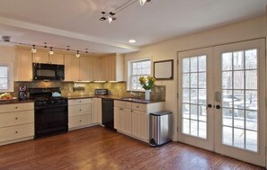 The newly-remodeled + fully-equipped kitchen opens onto a blue stone patio.