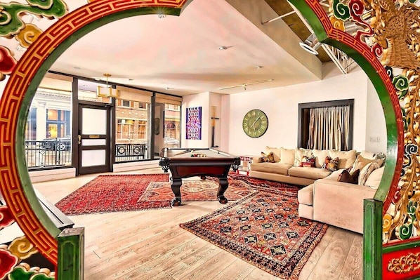 Sun flooded living room of Gallery Loft with large sofa and Pool table