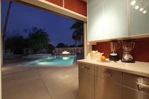 Poolside bar with large fridge and deep sink. Counter for blending cold drinks.