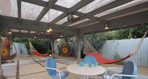 Huge shade patio with hammocks and hanging chairs, lights and fans.