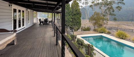 The deck wraps around the main cottage & looks over the pool, cabana & fire-pit