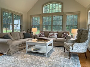 SUN ROOM with windows on 3 sides overlooking the water and the forest.