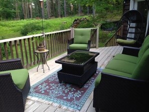 Seating area on deck surrounded by woods