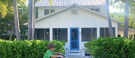 A favorite repeat renter riding his bike in front of my historic 1911 cottage.