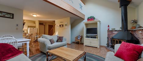 Living room with wood burning stove.  Couch, loveseat, and oversized chair. 