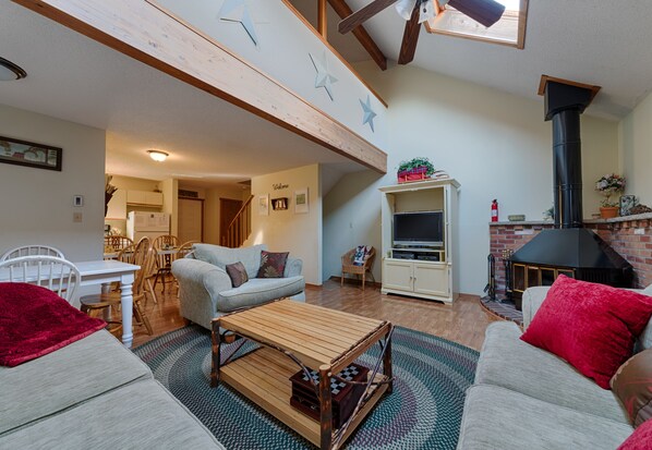 Living room with wood burning stove.  Couch, loveseat, and oversized chair. 