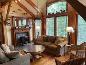 Large and bright sunroom area has gas fireplace and loads of comfy seating.