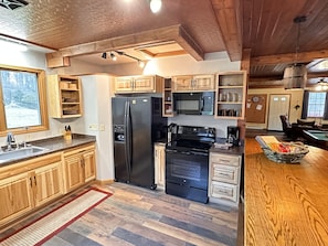 Kitchen newly remodeled in 2024 - added full stove, fridge, and washer / dryer