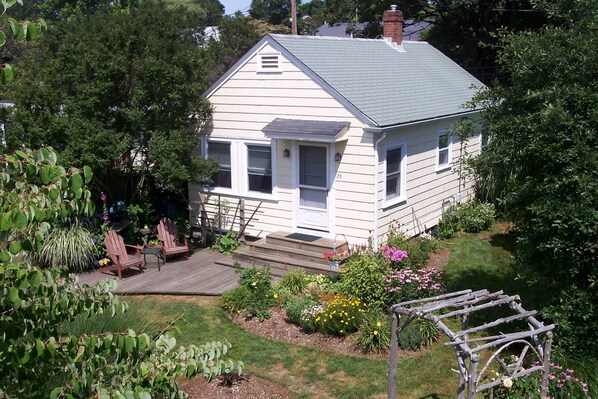 Beach cottage with deck and flowering gardens. 