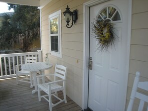 Welcoming front porch with table , chairs and rocking chairs for lazy days.