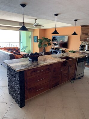 Unique kitchen island with custom stone work on three sides and huge granite top