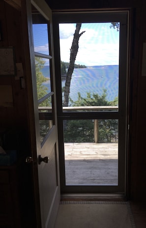 The screen door lets in the summer breeze and draws you to the view of the cove.
