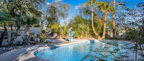 Mature desert landscaping highlights the refreshing pool, spa, and fountains.