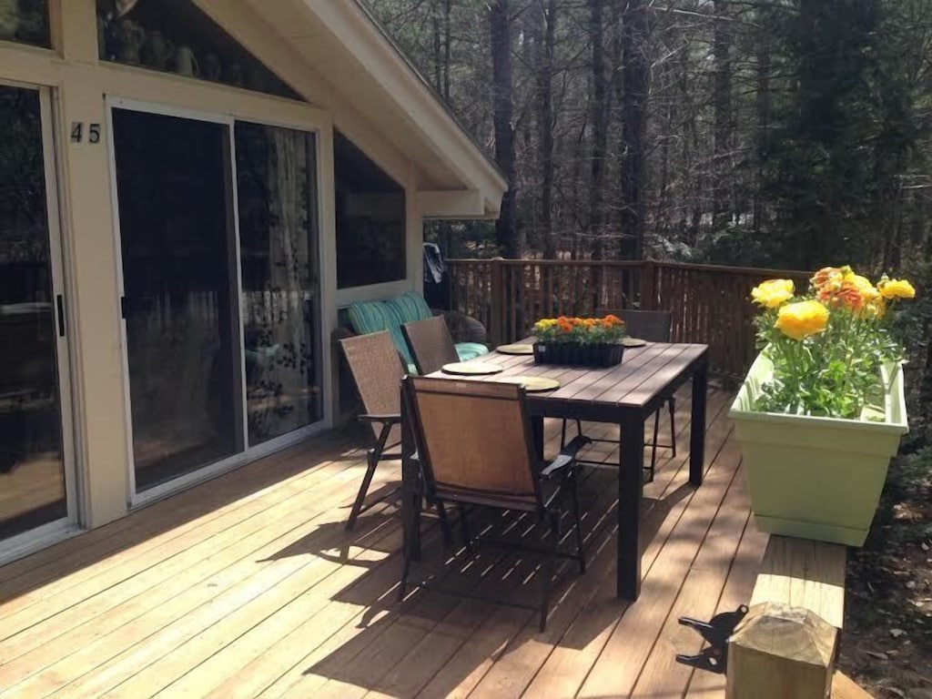 A deck with tables and chair in a White Mountains vacation rental