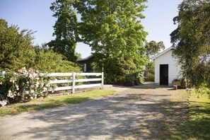 Mature gardens and trees shade Dairy House and its wood shed.