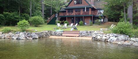 View of sandy beach, waterfront and slopping lawn to the house