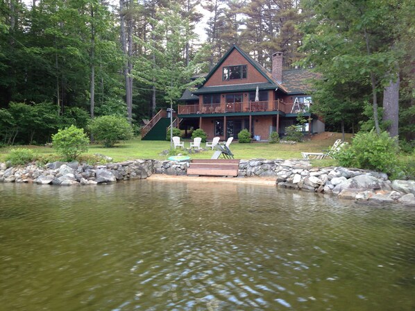 View of sandy beach, waterfront and slopping lawn to the house