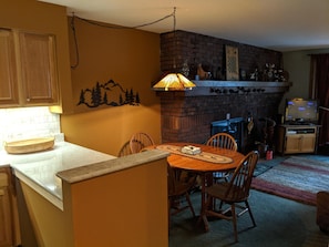 View of fireplace in living area from hallway in front of the Kitchen