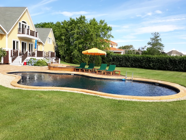 Lagoon shaped saltwater pool, lush landscaping, hedge lined for complete privacy