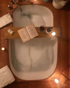 Luxurious master bath soaker tub with teak wood surround
