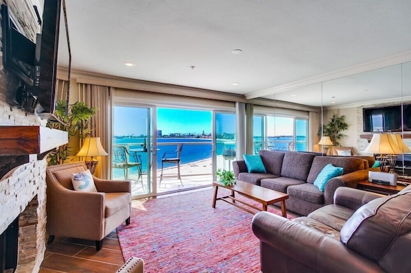 Living room with comfortable couches, TV , balcony and incredible views!