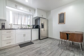 Renovated kitchen with pots, pans, cooking utensils, knifes, plates and cutlery