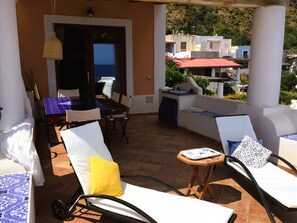 Terrace equipped with dining table and sun loungers 