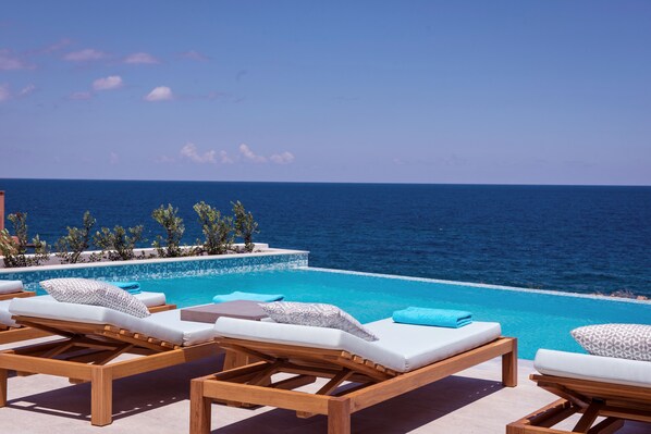 Lay by the pool while sunbathing and enjoy the magnificent sea views