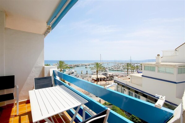 Private balcony facing south-west with outdoor dining area and sea views