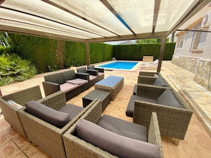 Shaded poolside sofa seating area 