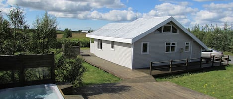 Back of house, hot tub and part of deck