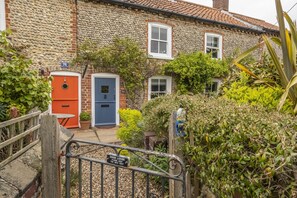 Muckledyke Cottage, Stiffkey: A romantic, character brick and flint cottage with a blue door