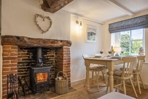 Muckledyke Cottage, Stiffkey: Dining area with seating for four guests and wood burning stove