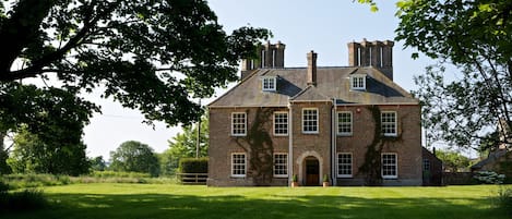 The front northern aspect of the house looking up through the avenue of trees.