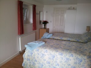 The sleeping area with twin beds and shower room beyond