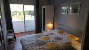 The bedroom has access to the balcony and a ceiling fan