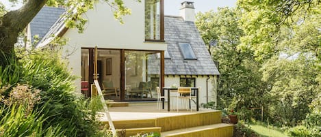 View from garden looking onto extensive decking area and large living room