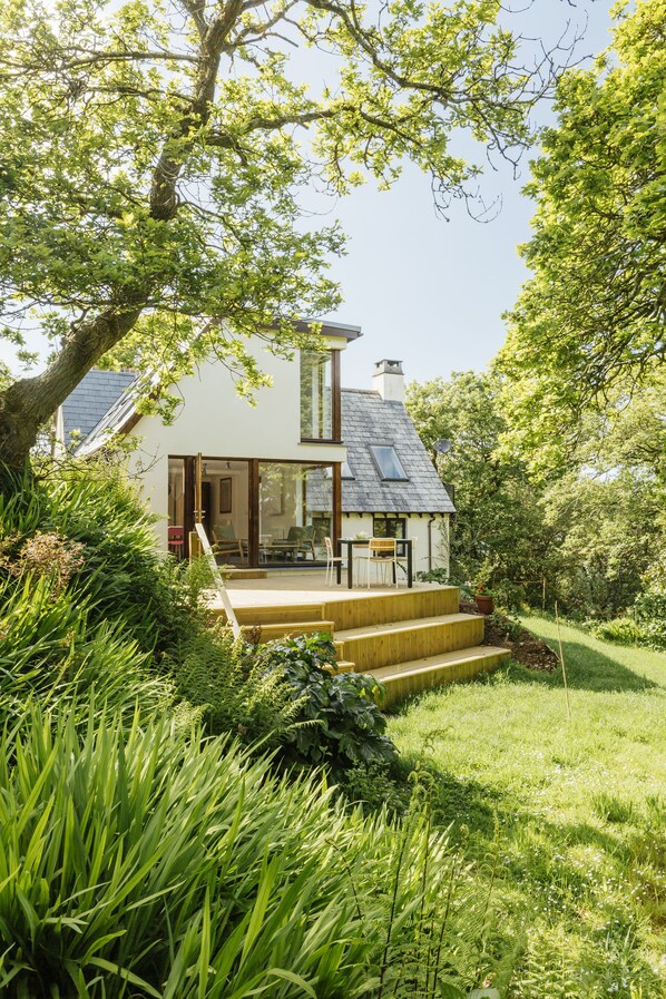 View from garden looking onto extensive decking area and large living room