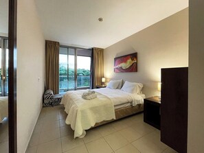 Bedroom with double bed, air-conditioning, wardrobe, bedside table and access to balcony 