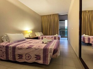 Single room with two single beds, air-conditioning, wardrobe, bedside table and access to balcony 