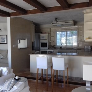 Well equipped kitchen with breakfast bar next to the sitting room.